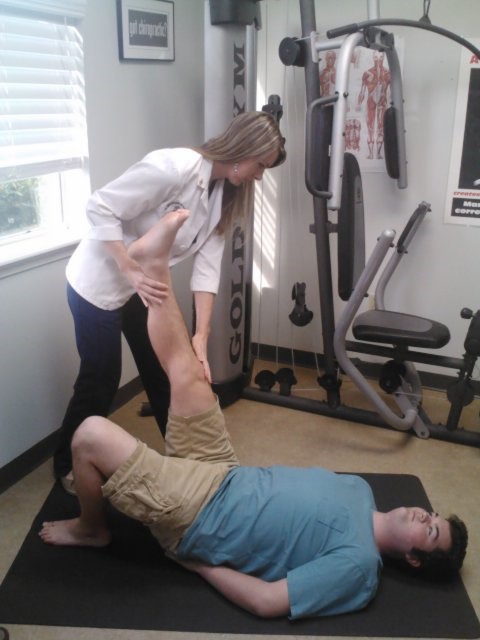 copyright © Absolute Injury and Pain Physicians Dr. Donnelly with a patient doing leg stretches
